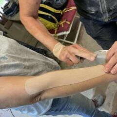 Eine Physiotherapeutin im Kurs tapt mit Erfolg einige Kursteilnehmerinnen!